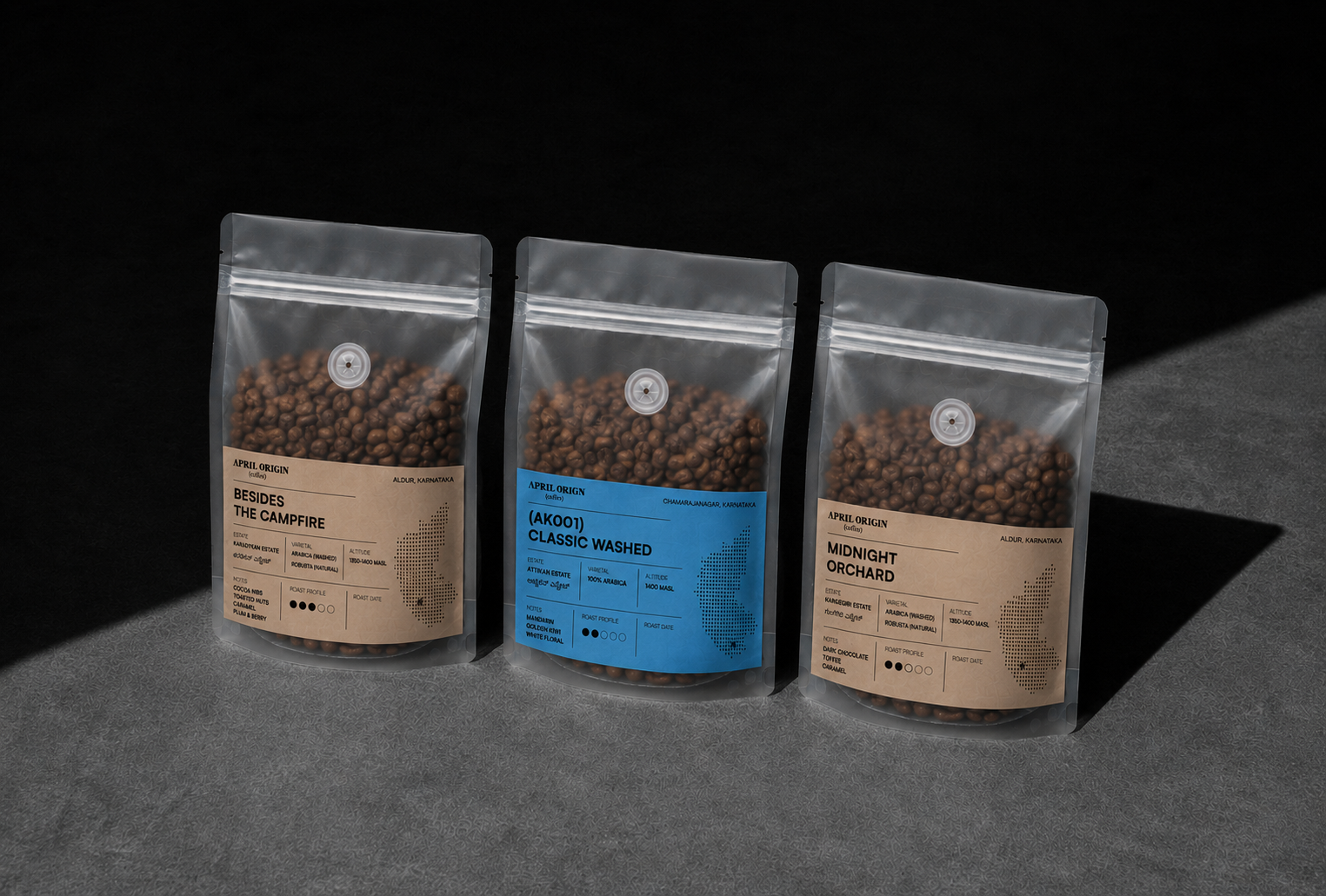 Three coffee packages with different labels on a dark background